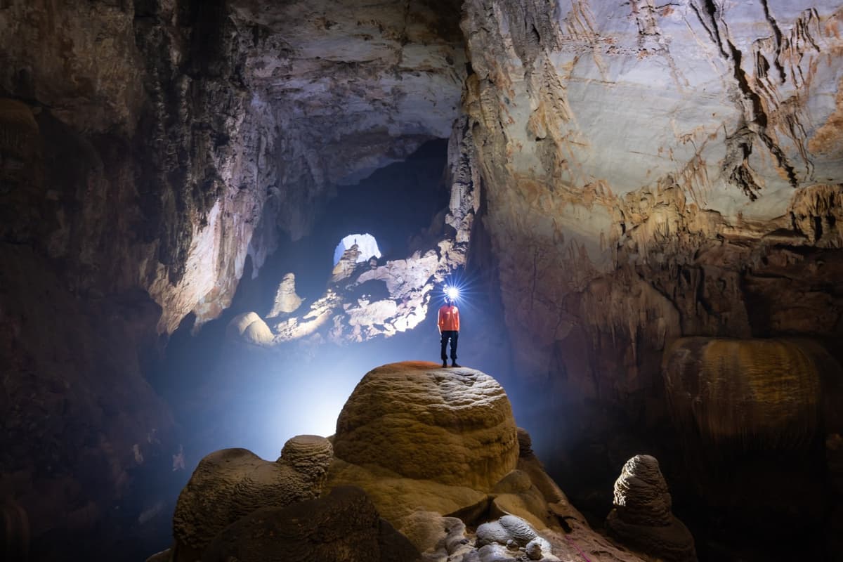 The Hand of Dog stalagmite towers behind, standing about 60 meters tall.