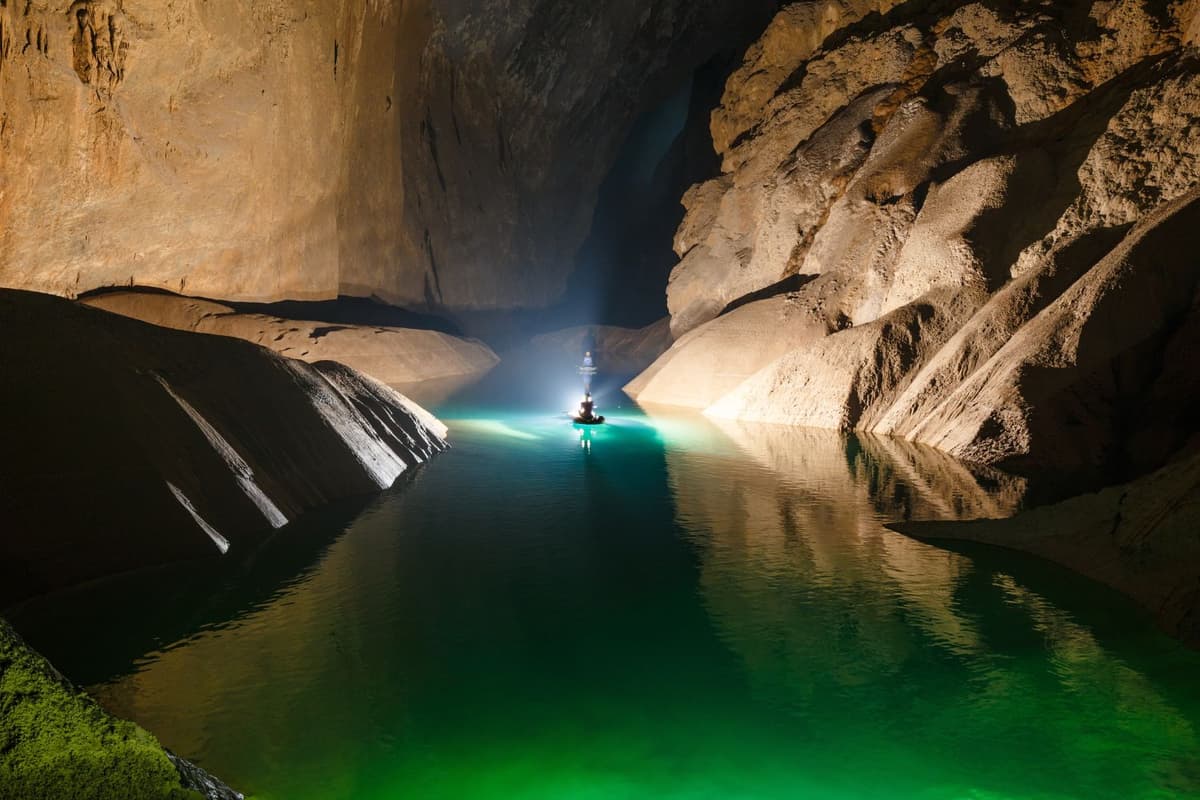Rafting across the serene underground lake inside the Passchendaele Passage to approach the base of the Great Wall of Vietnam.